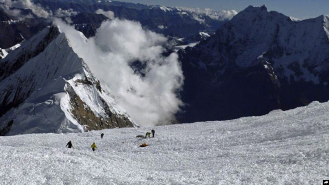 Para anggota tim SAR berusaha mencari korban hilang di antara reruntuhan salju longsor di Gunung Manaslu, Nepal utara (23/9). 