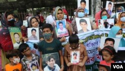নিখোঁজ স্বজনের ছবি নিয়ে পরিবারের সদস্যরা 