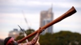 Seorang pria dari suku asli Aborigin memainkan alat musik didgeridoo upacara penyambutan di kantor pemerintahan di Sydney, Australia, pada 28 Juni 2017. (Foto: Reuters/David Gray)