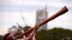 Seorang pria dari suku asli Aborigin memainkan alat musik didgeridoo upacara penyambutan di kantor pemerintahan di Sydney, Australia, pada 28 Juni 2017. (Foto: Reuters/David Gray)