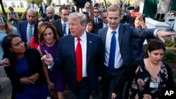 President Donald Trump walks to an interview on the North Lawn of the White House, Friday, June 15, 2018, in Washington. 