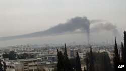 Smoke billows in Homs after the city is shelled by what activists say were Syrian troops, February 17, 2012.