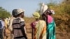 FILE - Women and girls speak to members of a U.N. peacekeeping patrol as they walk to get food in Bentiu, fearful of being attacked on the way, near Nhialdu, South Sudan, Dec. 7, 2018.