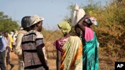 FILE - Women and girls speak to members of a U.N. peacekeeping patrol as they walk to get food in Bentiu, fearful of being attacked on the way, near Nhialdu, South Sudan, Dec. 7, 2018.