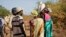 FILE - Women and girls speak to members of a U.N. peacekeeping patrol as they walk to get food in Bentiu, fearful of being attacked on the way, near Nhialdu, South Sudan, Dec. 7, 2018.