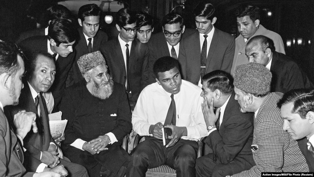 FILE - Muhammad Ali speaks to Muslims holding a book called "Towards Understanding Islam" written by Sayyid Abul Ala Maududi in London, Britain, May 1966. Ali died late Friday in Phoenix, Arizona, June 3, 2016.