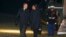 President Barack Obama and first lady Michelle Obama walk on the South Lawn at the White House in Washington, Dec. 11, 2013, after returning from a memorial service for former South African President Nelson Mandela in South Africa.