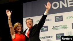 John Tory waves with his wife Barbara Hackett after being elected as mayor in Toronto, Oct. 27, 2014. 