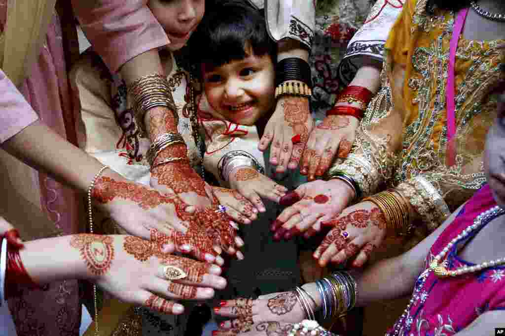 Muslims girls display their hands painted with traditional henna to celebrate Eid al-Fitr holidays, marking on the end of the fasting month of Ramadan, in Peshawar, Pakistan.