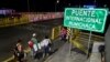 Miembros de una familia cruzan el Puente Internacional Rumichaca, en la frontera entre Ipiales en Colombia, y Tulcán en Ecuador, el 23 de agosto de 2018.
