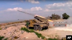 FILE - In this Friday, March 31, 2017 frame grab from video provided by the government-controlled Syrian Central Military Media, Syrian army rocket launcher fires at insurgent groups position, in Hama, north Syria.