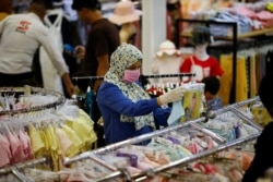 Seorang perempuan Irak memakai masker di tengah pandemi COVID-19, menjelang Idulfitri, di Baghdad, Irak 19 Mei 2020. (REUTERS/Thaier al-Sudani)