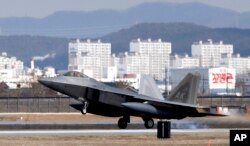 FILE - One of four U.S. F-22 stealth fighters lands at Osan Air Base in Pyeongtaek, South Korea, Feb. 17, 2016. Four U.S. F-22 stealth fighters flew over South Korea in a show of power against North Korea.