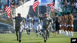 Quân nhân Mỹ dẫn các cầu thủ bóng bầu dục của đội Jacksonville Jaguars vào sân trước trận đấu với đội Miami Dolphins ở Jacksonville, Florida, ngày 20/9/2015.