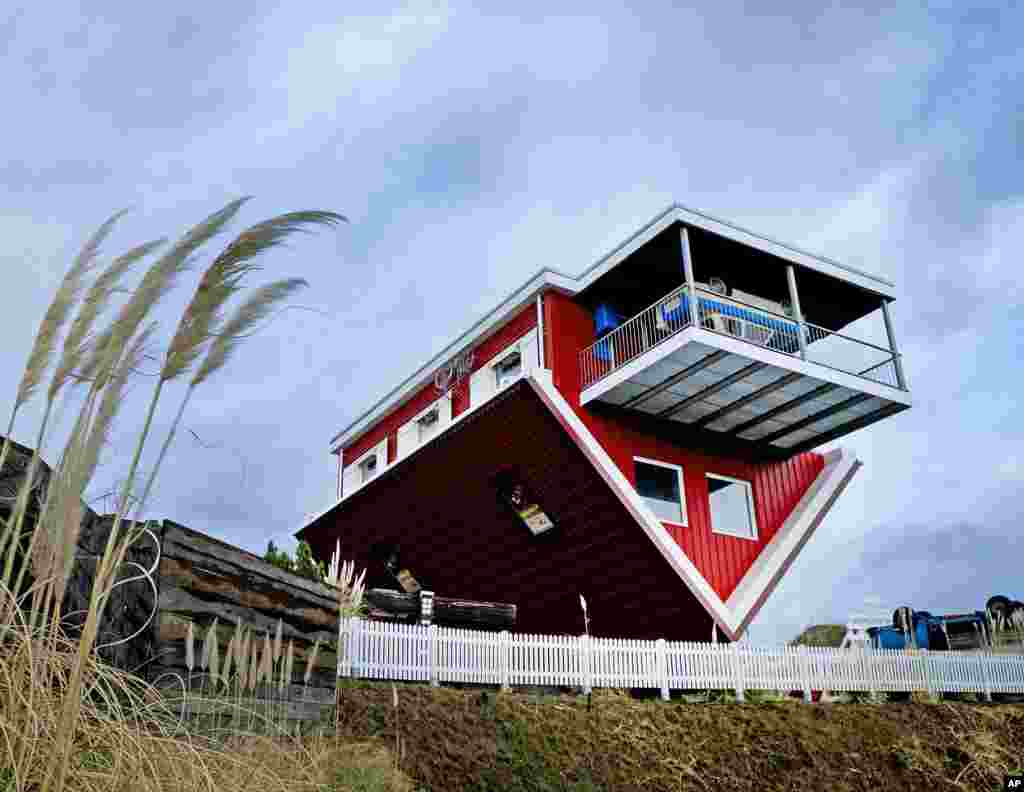 An upside down house, open to the public as a tourist attraction, stands on a hill near the highway in Wertheim, southern Germany, March 4, 2019.