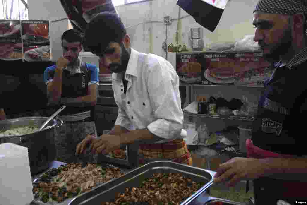 Free Syrian Army members prepare food for their fellow fighters in a kitchen located near the frontline in the al-Khalidiya neighborhood of Aleppo, Sept. 22, 2013.