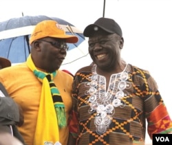 Former Prime Minister Morgan Tsvangirai shares a joke with his former finance minister, Tendai Biti, at a rally of about 500 people in Harare, March 22, 2017. Tsvangirai said the next election is heading for a dispute unless the Zimbabwe Electoral Commission steps aside. (S. Mhofu/VOA)