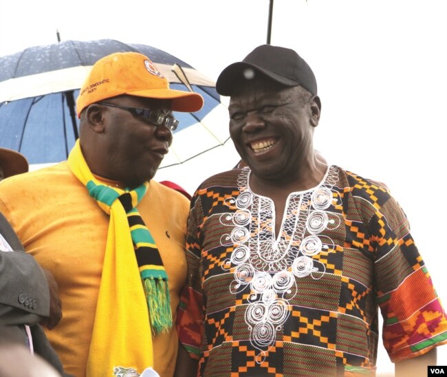 Former Prime Minister Morgan Tsvangirai shares a joke with his former finance minister, Tendai Biti, at a rally of about 500 people in Harare, March 22, 2017. Tsvangirai said the next election is heading for a dispute.