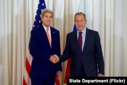 ທ່ານ John Kerry ຈັບມືກັບ ລມຕ ຕ່າງປະເທດຣັດເຊຍ ທ່ານ Sergey Lavrov ກ່ອນພົບປະກັນ ຢູ່ເຈນີວາ.