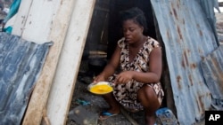 19-year-old Nathanaelle Bernard, who is 7 months pregnant, cooks an omelet in a makeshift hut she is sharing with five members of her extended family, in Coteaux, Haiti, Nov. 1, 2016. Hundreds of thousands of people in southern Haiti are facing food shortages three months after Hurricane Matthew.