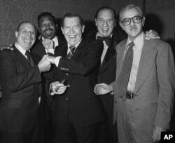 FILE - Comedian Henny Youngman, second from right, clowns with celebrities, left to right, Don Rickles, Sugar Ray, Milton Berle and Jack Albertson in the Beverly Hills, California Hilton, Nov. 17, 1978.