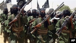 FILE - Al-Shabab fighters march with their guns during military exercises on the outskirts of Mogadishu, Somalia.