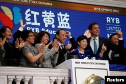 Chimin Cao, Co-Founder and Chairman for RYB Education Institution and Yanlai Shi, Co-Founder and CEO for RYB Education Institution, ring the opening bell together to celebrate their company's IPO at the New York Stock Exchange in New York, Sept. 27, 2017.