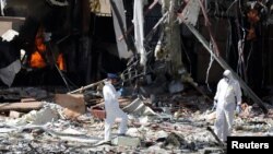 Forensic experts work the scene at a community hall where Saudi-led calition warplanes struck a funeral gathering in Sana'a, the capital of Yemen, Oct. 9, 2016.