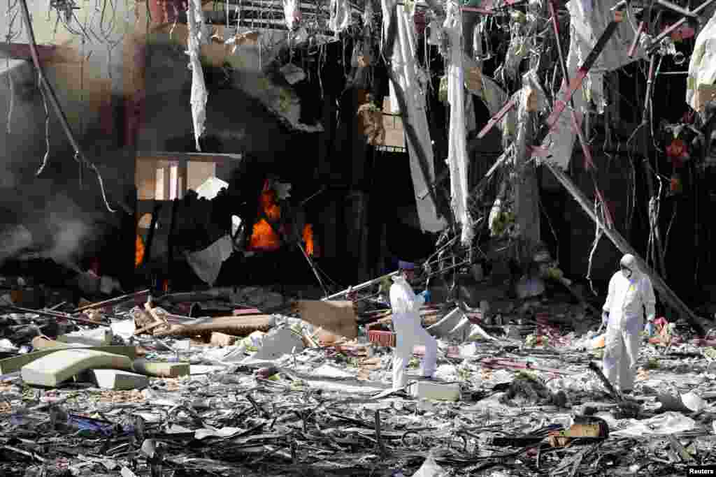 Investigadores inspecionam edificio destruido por aviões sauditas e onde decorriam cerimónias fúnebres em Sana, capital do Iemen.