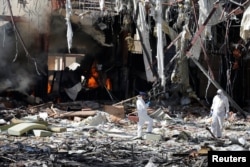 FILE - Forensic experts investigate the scene at the community hall where Saudi-led warplanes struck a funeral in Sana'a, Yemen, Oct. 9, 2016.