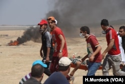 After the fence is breached, ambulances roar out to protesters carrying the wounded, May 14, 2018. However, without enough vehicles, many of the injured are carried out by fellow protesters.