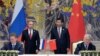 Russia's President Vladimir Putin (Background L) and China's President Xi Jinping (Background R) watch during a signing ceremony in Shanghai, China, May 21, 2014.