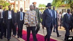 South Sudan's rebel leader and now Vice President Riek Machar, center left, walks with President Salva Kiir after being sworn in at the presidential palace in the capital Juba, South Sudan, April 26, 2016.