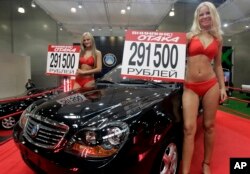 FILE - Models advertise "Geely Otaka," a car designed in China, during an auto show in Moscow, Russia.