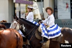 Una niña monta un caballo mientras los partidarios del presidente electo de Uruguay, Luis Lacalle Pou, esperan que él llegue para su ceremonia de juramento, en Montevideo, Uruguay, el 1 de marzo de 2020.