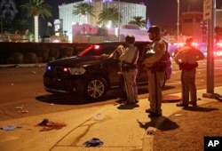 Police stand at the scene of a shooting along the Las Vegas Strip, Oct. 2, 2017, in Las Vegas.