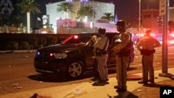 Police stand at the scene of a shooting along the Las Vegas Strip, Oct. 2, 2017, in Las Vegas. 