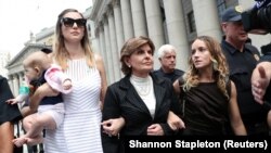Gloria Allred, yang mewakili tersangka korban Jeffrey Epstein, bersama Teala Davies dan seorang perempuan dan bayi tak dikenal, meninggalkan pengadilan di New York, 27 Agustus 2019. 