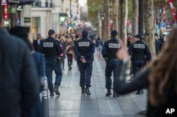 French police officers patrol on the Champs Elysees in Paris, Nov. 15, 2015. Thousands of French troops deployed around Paris on Sunday and at tourist sites.