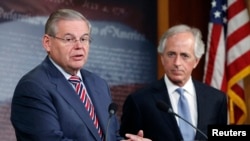 U.S. Senate Foreign Relations Committee Chairman Robert Menendez (L) and ranking member Senator Bob Corker (R) hold a news conference after a Senate vote on an aid package for Ukraine at the U.S. Capitol in Washington March 27, 2014.