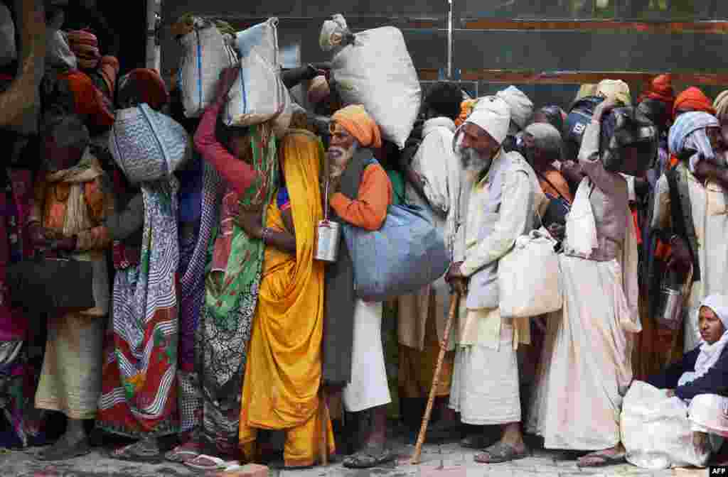 Indian Sadhus (holy men) queue to receive blankets during a Sadhu congregation following the Diwali Festival in Amritsar.