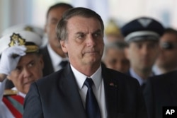 Brazil's President Jair Bolsonaro arrives for the inauguration ceremony of his new naval commander, Ilques Barbosa Junior, at the Naval Club in Brasilia, Jan. 9, 2019.