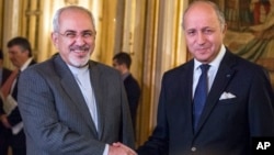 法国外长法比尤斯（右）和伊朗外长扎里夫11月3日在巴黎会晤前握手