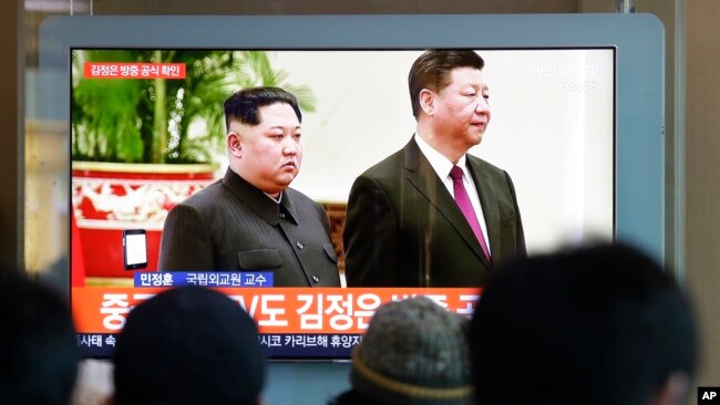 2019年1月8日在韩国首尔火车站，人们观看关于朝鲜领导人金正恩和中国国家主席习近平的电视新闻。