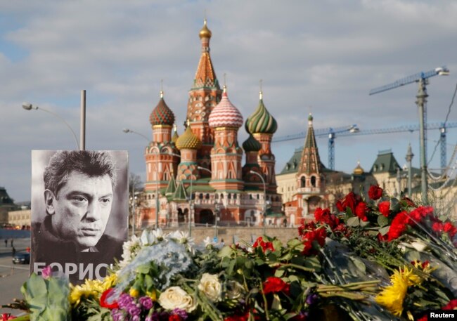FILE - A portrait of Kremlin critic Boris Nemtsov and flowers are pictured at the site where he was killed on February 27, with St. Basil's Cathedral seen in the background, at the Great Moskvoretsky Bridge in central Moscow, March 6, 2015.