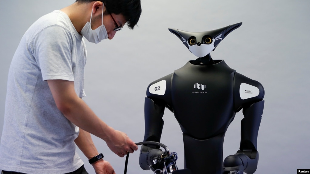 A staff member of Telexistence checks the company's shelf-stacking avatar robot, designed to resemble a kangaroo and developed to work in a convenience store in Tokyo, Japan July 3, 2020. (REUTERS/Issei Kato)
