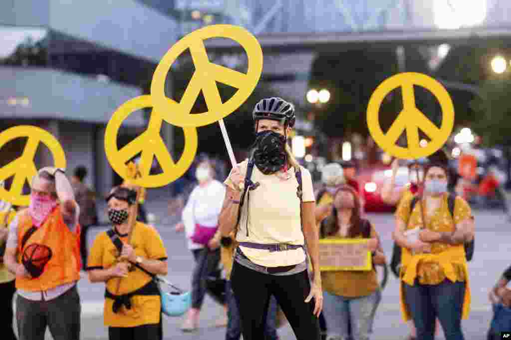 Mary Hubert, part of a &quot;wall of moms,&quot; holds a peace sign during a Black Lives Matter rally, July 22, 2020, in Portland, Oregon.