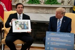 El presidente Donald Trump escucha al gobernador de Florida, Ron DeSantis, durante un evento en la Casa Blanca en Washington el 28 de abril de 2020.