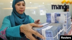 Kasir di kantor cabang Bank Mandiri sedang menghitung mata uang Rupiah di Jakarta 20 Juli 2015. (Foto: Antara via Reuters)
