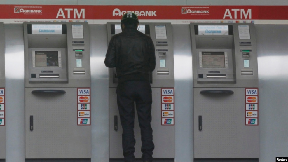 Một người đàn ông tại máy rút tiền tự động của ngân hàng Agribank. (Ảnh minh họa)